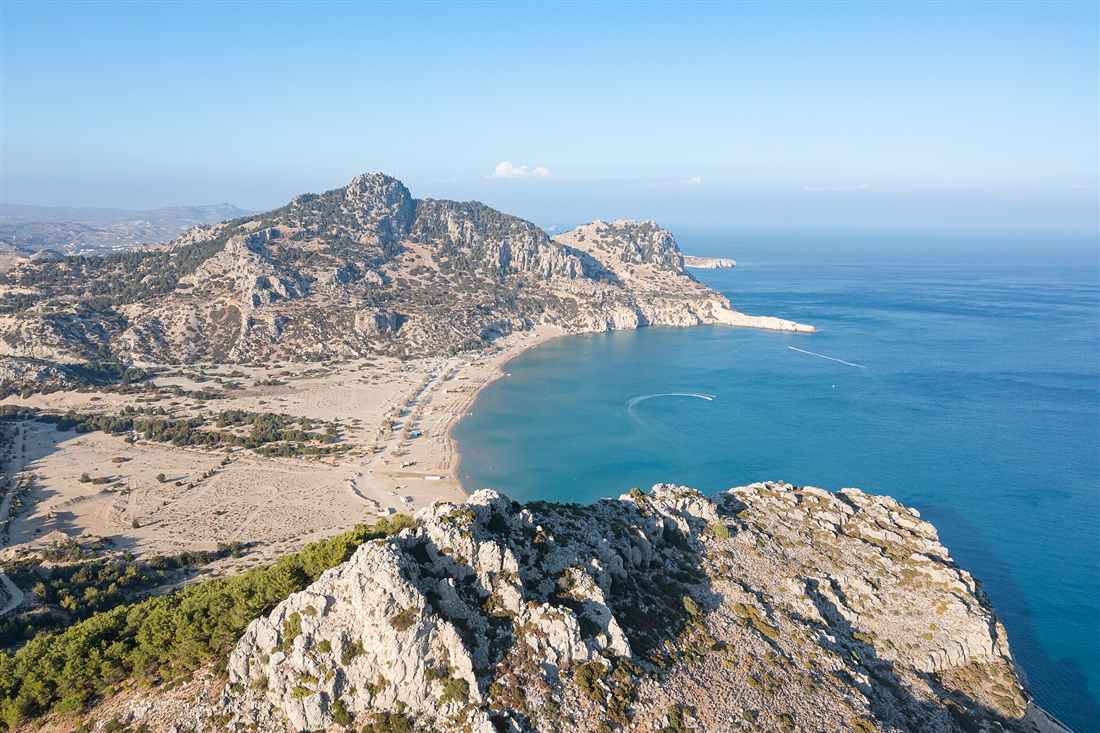 The long sand and turquoise bay of Tsambika on the east coast of Rhodes, the kind of open shoreline a Rhodes horse riding beach ride follows