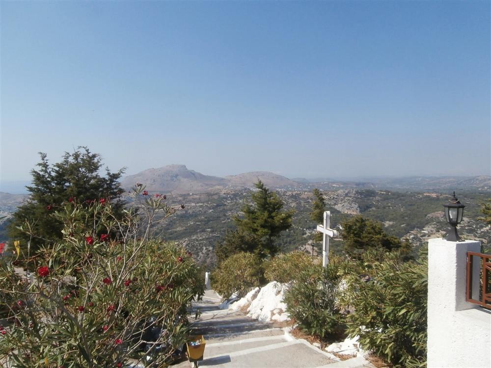 The view inland over the hills of Rhodes from a whitewashed hilltop chapel terrace