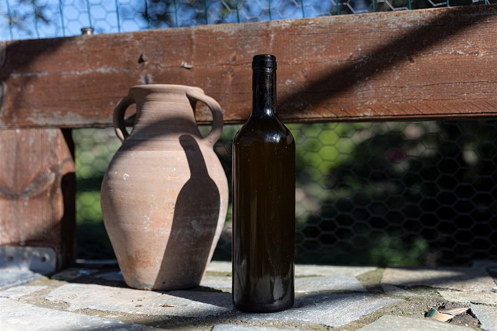 Rhodes olive oil tasting: a bottle of fresh Rhodes olive oil beside a clay amphora