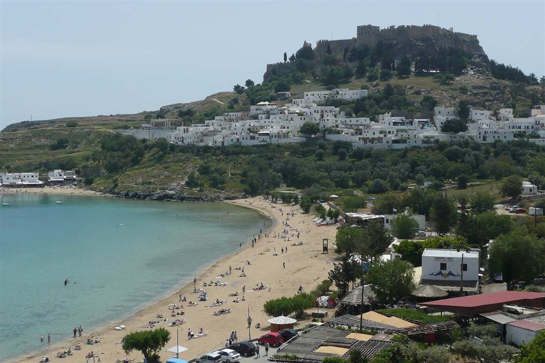 The acropolis above the white village and beach of Lindos on Rhodes