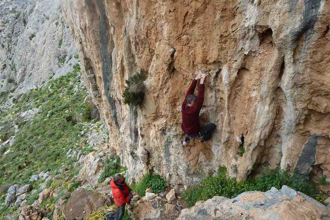 Rhodes rock climbing: a climber on a Dodecanese limestone wall with a belayer below
