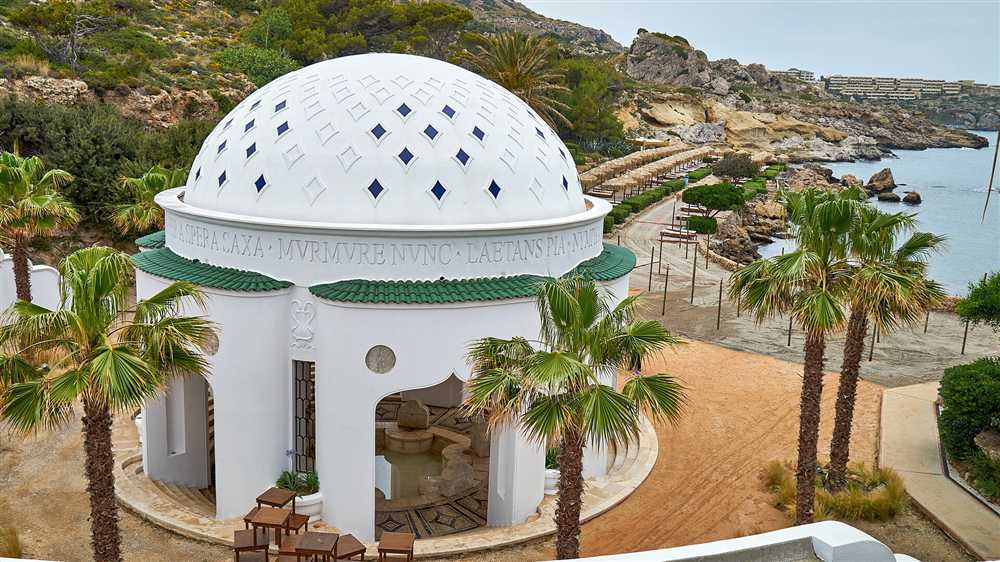 The domed rotunda and palms of Kallithea Springs above the rocky bathing coves on the east coast of Rhodes