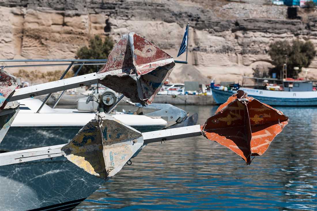 Small boats moored at Vlychada marina on the south coast of Santorini, the base for a licence-free boat rental