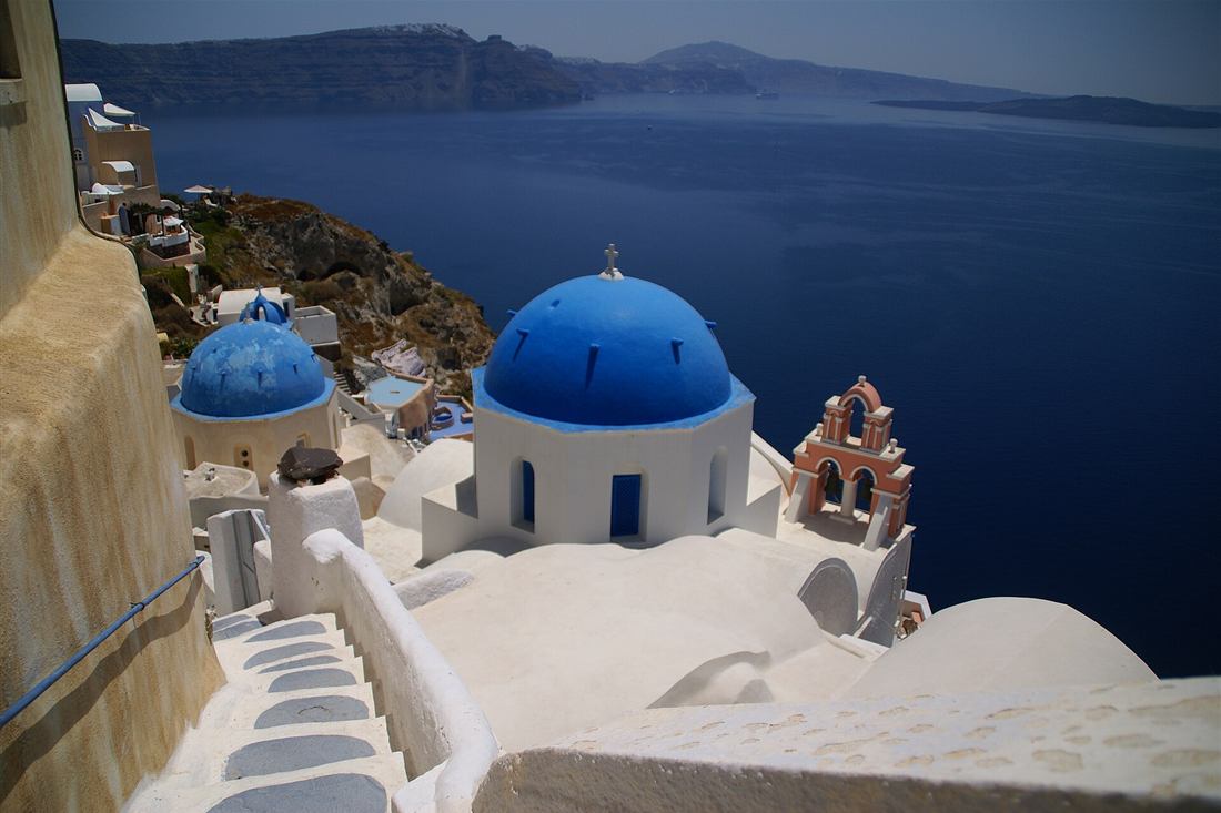 Blue-domed churches of Oia above the Santorini caldera, the highlight of a Santorini day trip from Crete