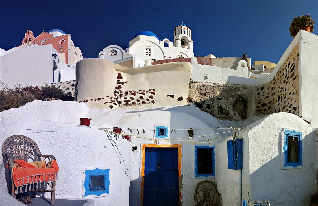 The whitewashed lanes and blue-domed church of Firostefani, where a Santorini food tour begins