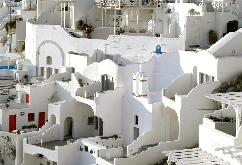 Terraced cave houses and vaulted roofs stepping down the caldera at Firostefani on Santorini