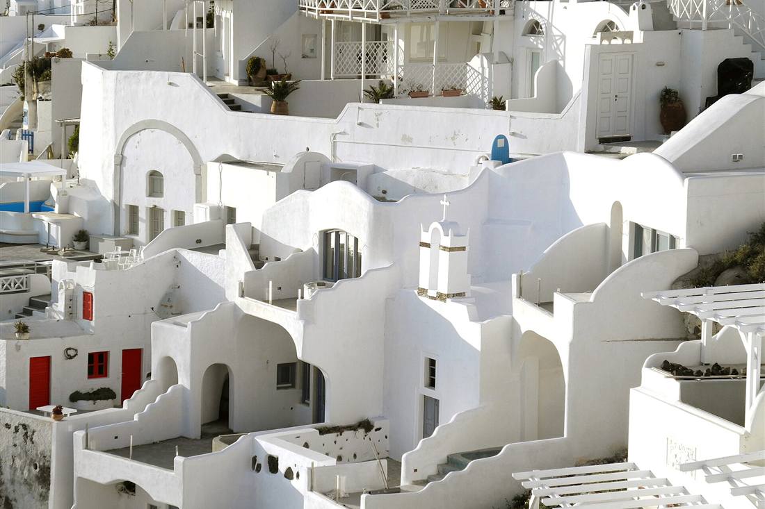 Whitewashed cliffside houses and a bell tower at Firostefani, the caldera-rim stop on a Santorini private tour with local guide