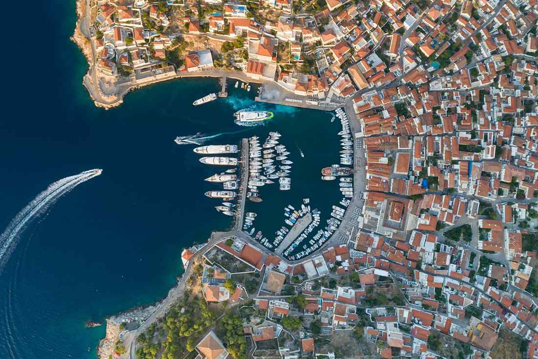 The crescent harbour of Hydra town from the air, Saronic Gulf, Greece