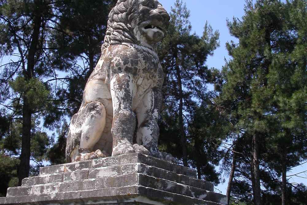 The marble Lion of Amphipolis on its base among the pines