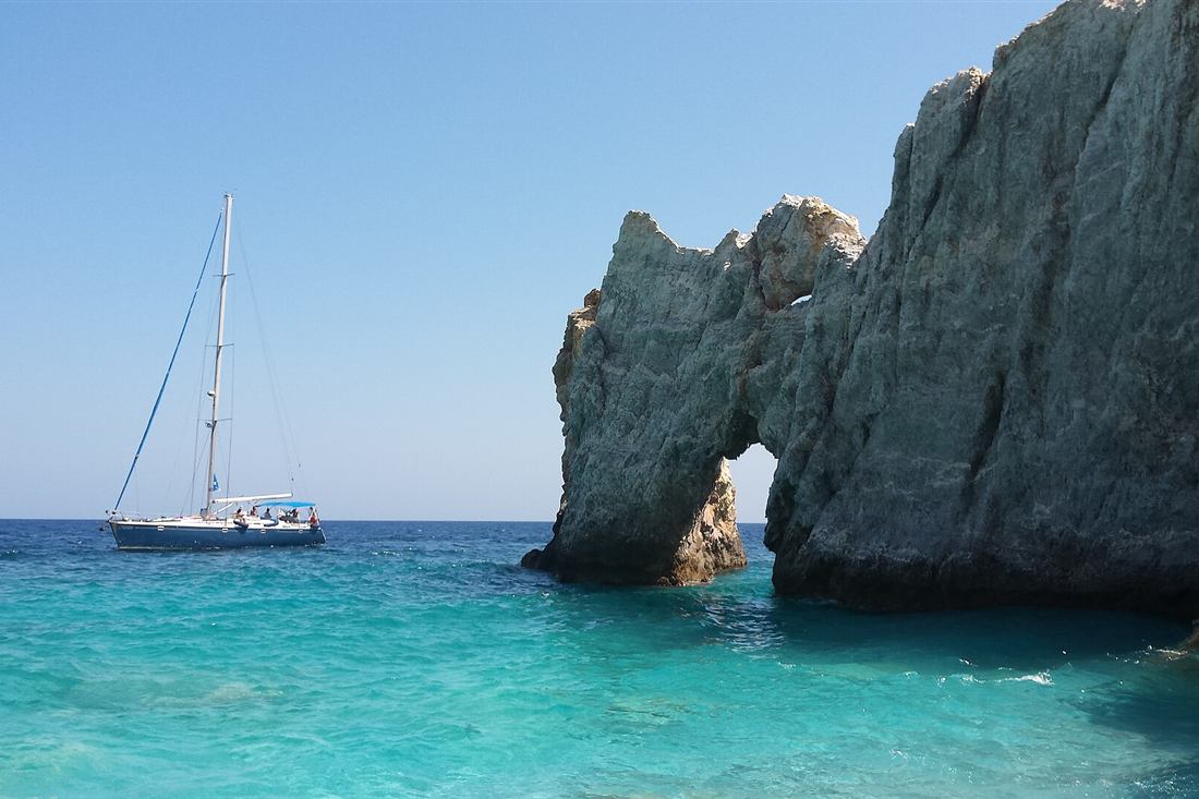 A yacht anchored beside the Tripia Petra arch at Lalaria on a Skiathos boat rental