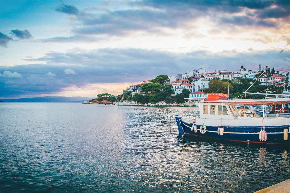 A wooden day boat moored at the old port of Skiathos in the evening light