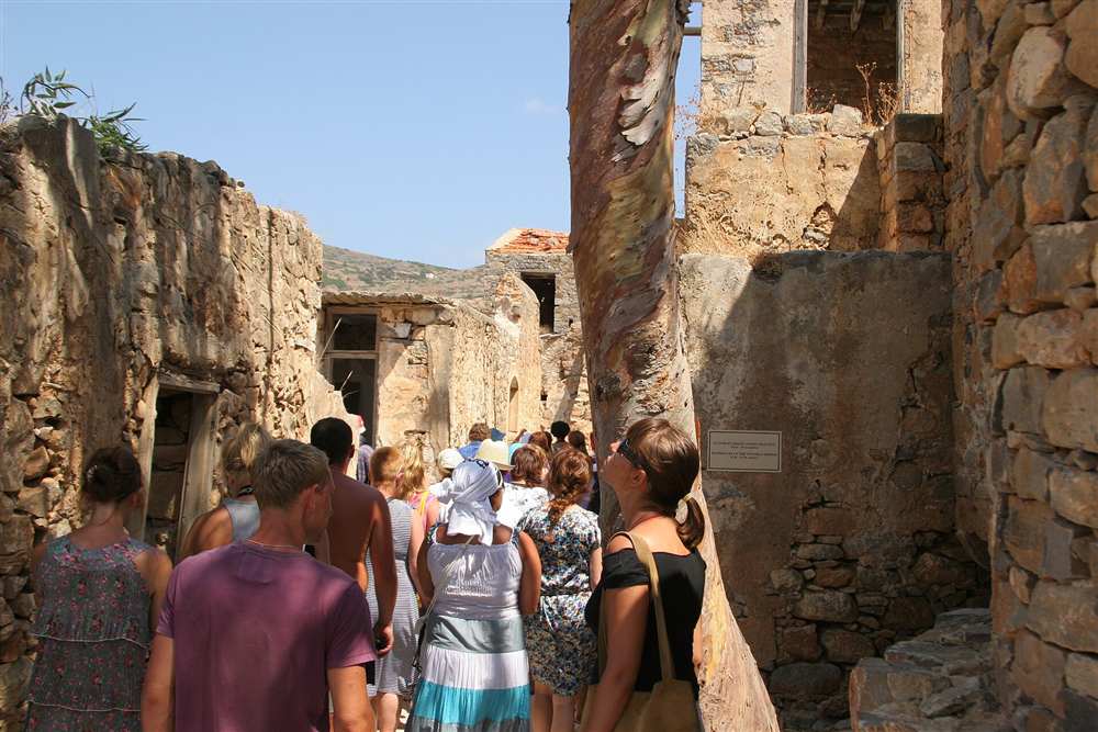 Spinalonga boat trip visitors walking the old colony street on Spinalonga island