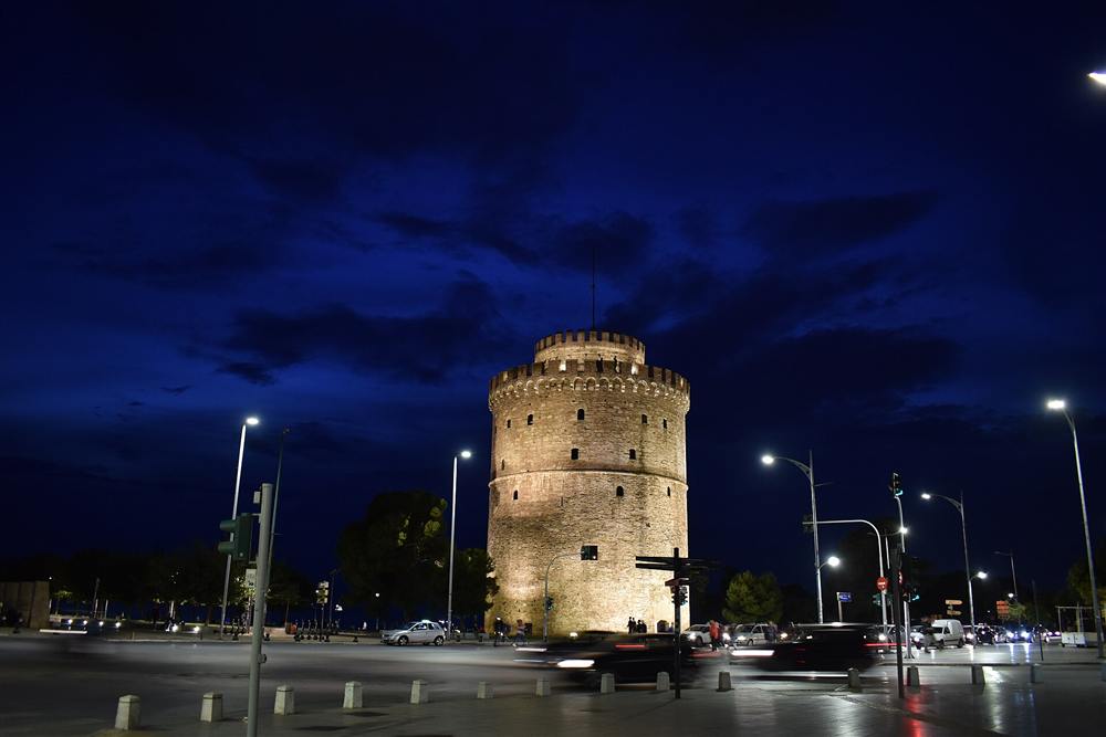 The floodlit White Tower on the Thessaloniki waterfront at dusk