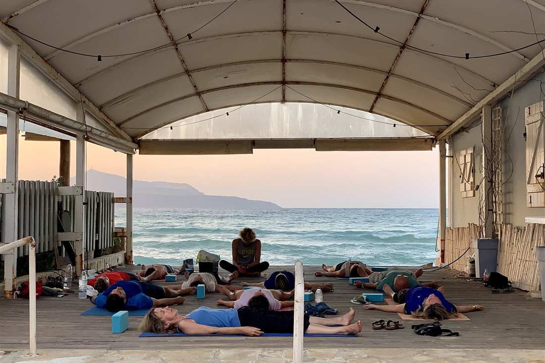 Thessaloniki yoga class: a seaside yoga group resting on mats facing the Aegean in Greece