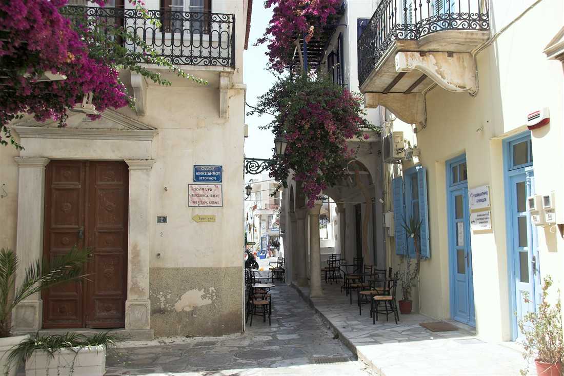 A lane in the old town of Chora on Tinos with bougainvillea over the balconies
