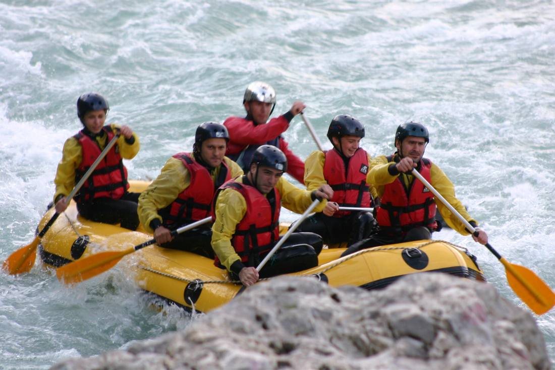 A raft crew in helmets and life jackets on the Arachthos river in Tzoumerka