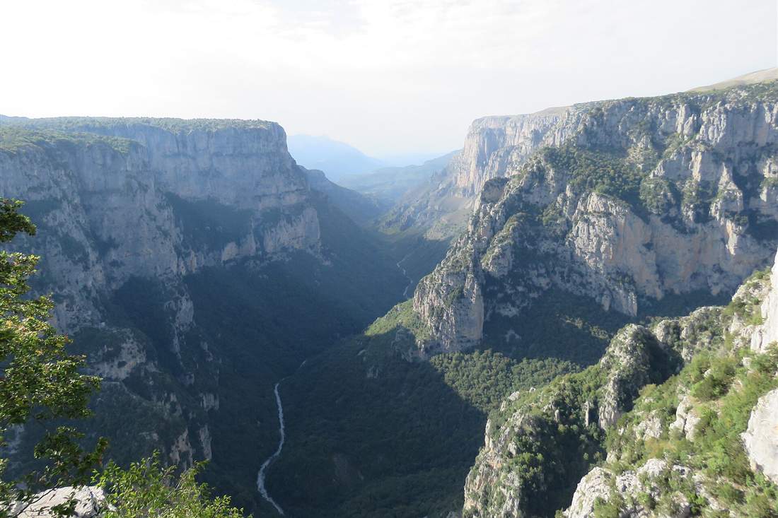 The Vikos gorge from the Beloi viewpoint with the white riverbed running between the cliffs, the canyon a Vikos gorge hike crosses