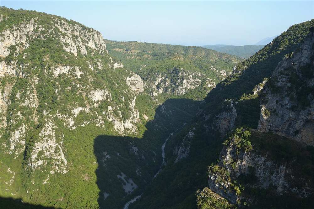 The gorge walls deeper along the canyon with the Voidomatis riverbed below, the middle section of the traverse