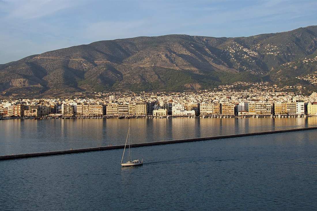 Volos waterfront and city under Mount Pelion in golden evening light, the route of a Volos walking tour