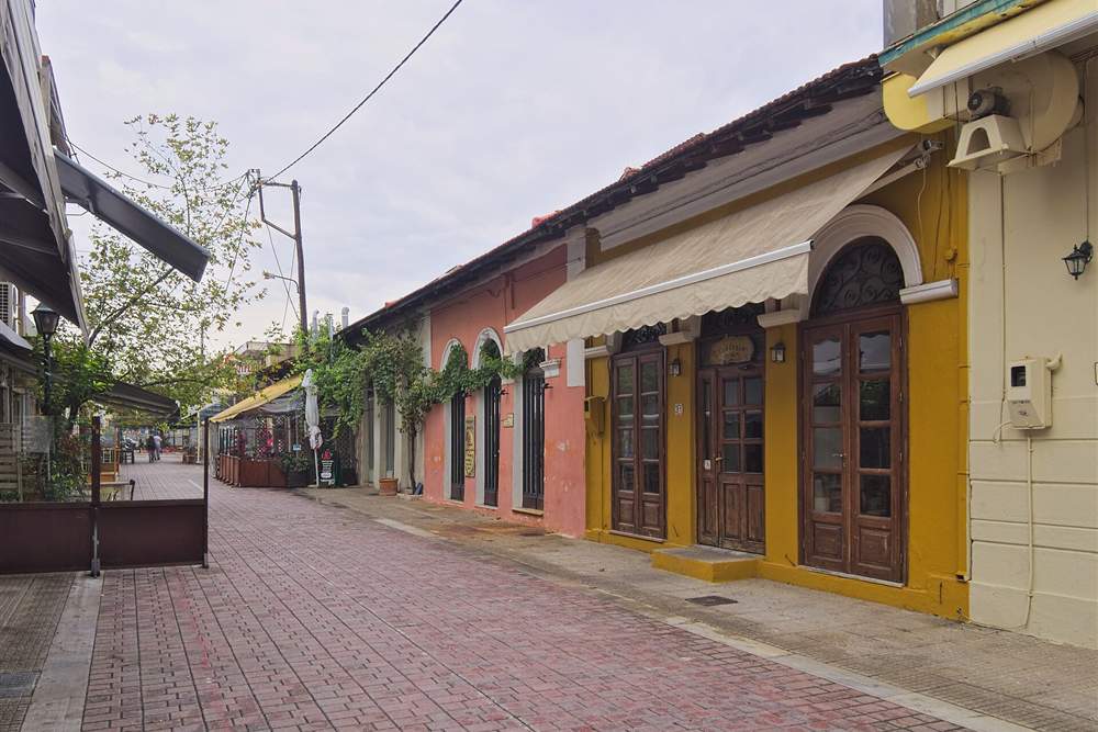 Colourful restored shopfronts on a pedestrian street in the Palia district of Volos