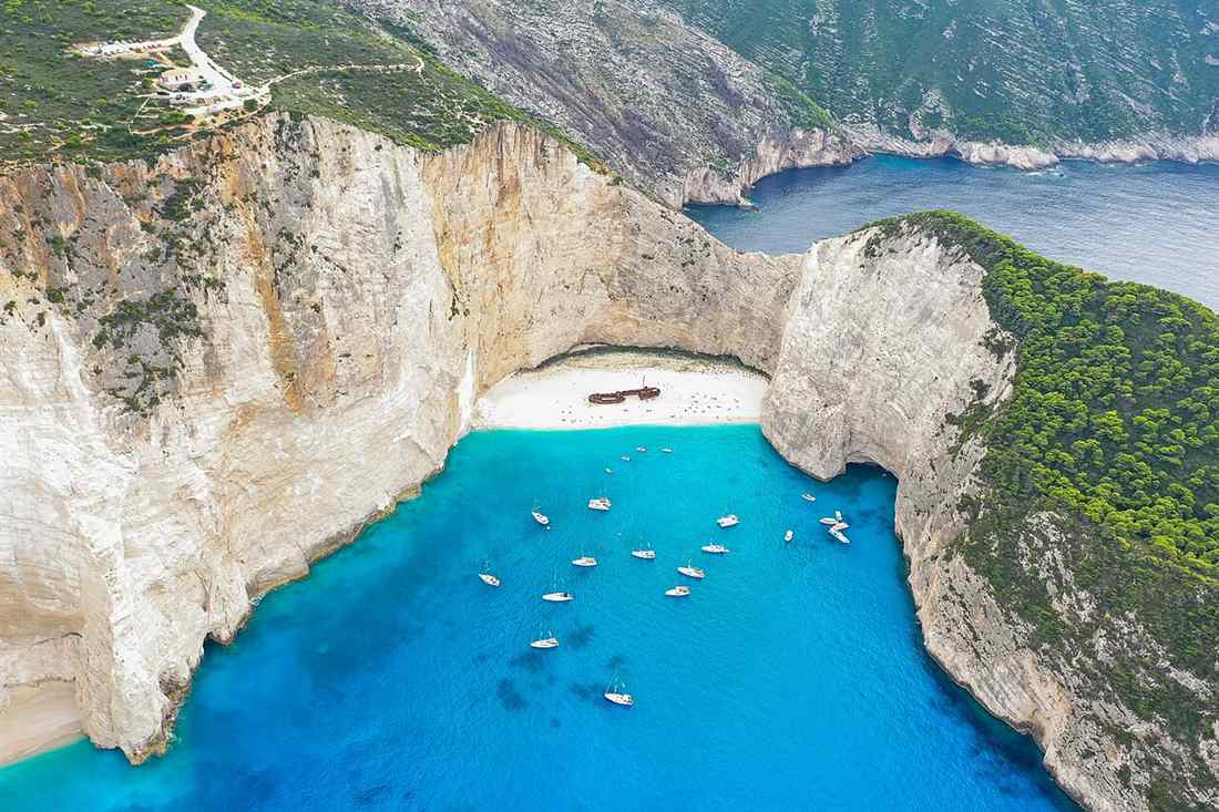 Boats anchored in the turquoise water of Navagio shipwreck cove on Zakynthos