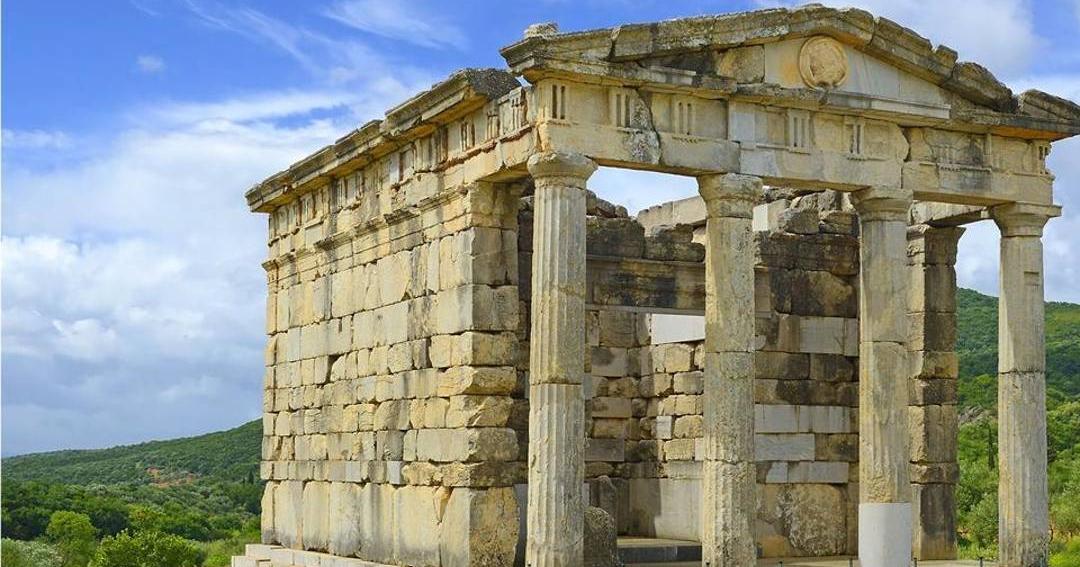 The columned stone tomb monument at the end of the stadium of Ancient Messene, with its triangular pediment.