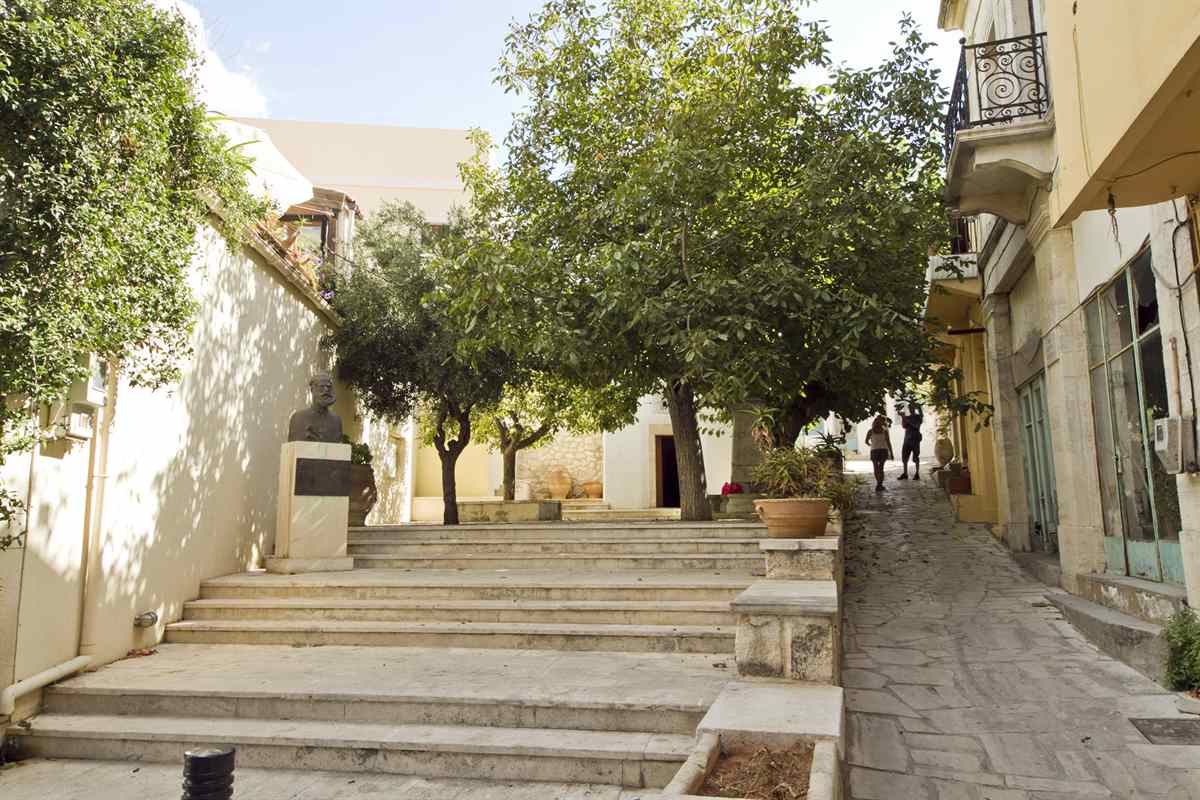 Stone steps, shade trees and restored houses on a lane in the centre of Archanes village, a stop on Archanes tours south of Heraklion