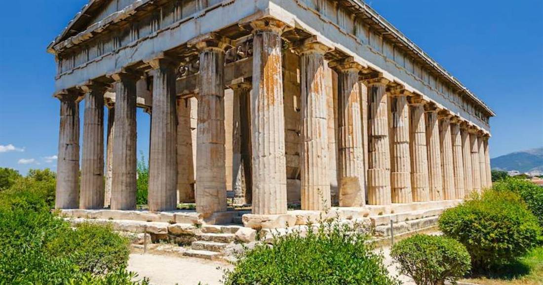 The Doric columns of the Temple of Hephaestus in the Ancient Agora of Athens under a clear blue sky, a site on the Athens city pass.