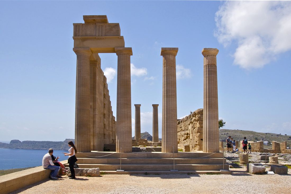 Tall stone columns of the temple on the Lindos acropolis, with the sea and blue sky behind