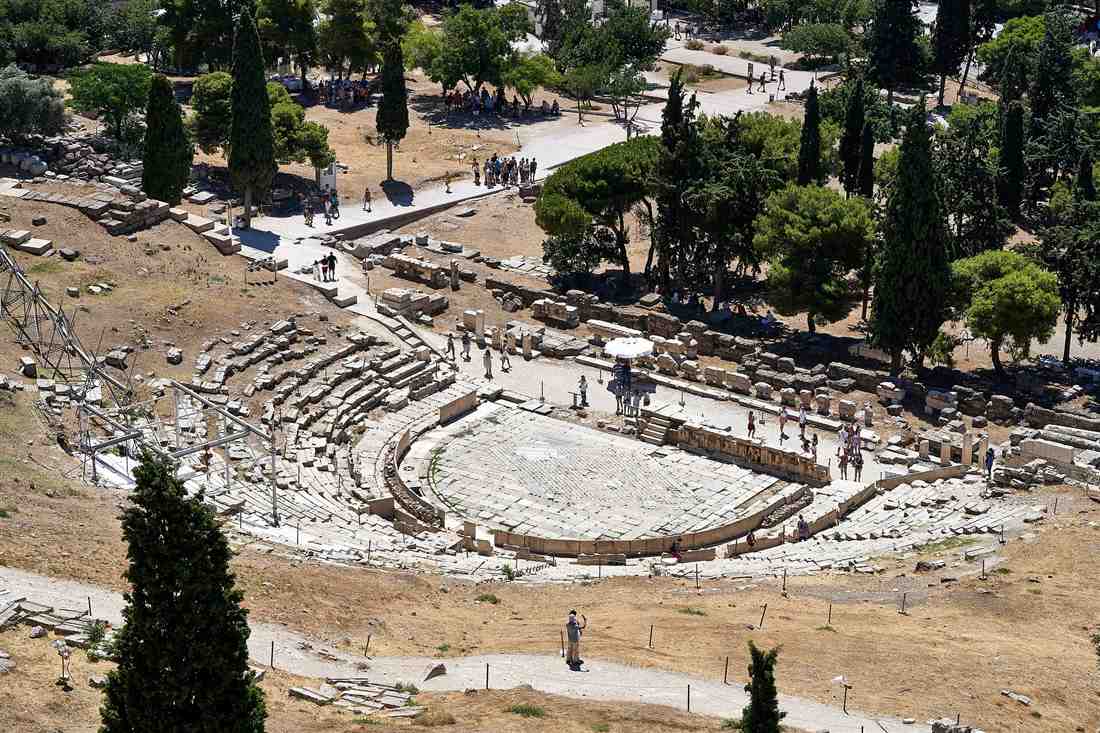 The stone seats and round orchestra of the Theatre of Dionysus below the Acropolis, where theatre began in Athens and where an Athens theater show story starts.