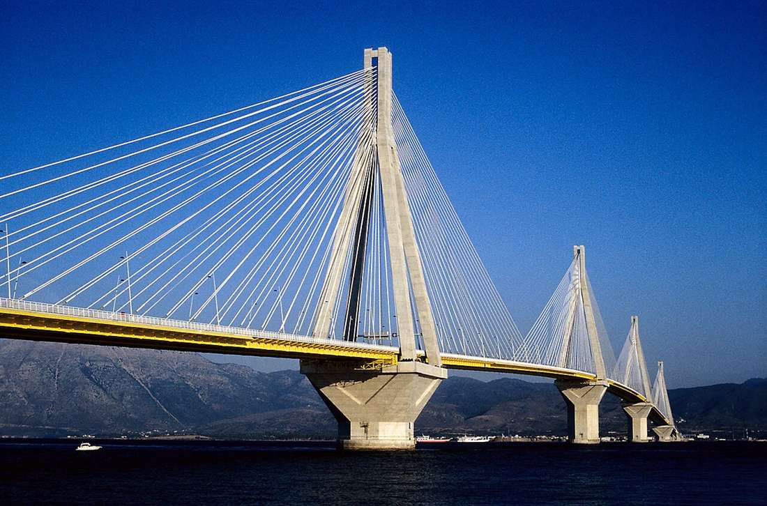 The Rio–Antirrio cable-stayed bridge over the Gulf of Corinth under a clear blue sky.