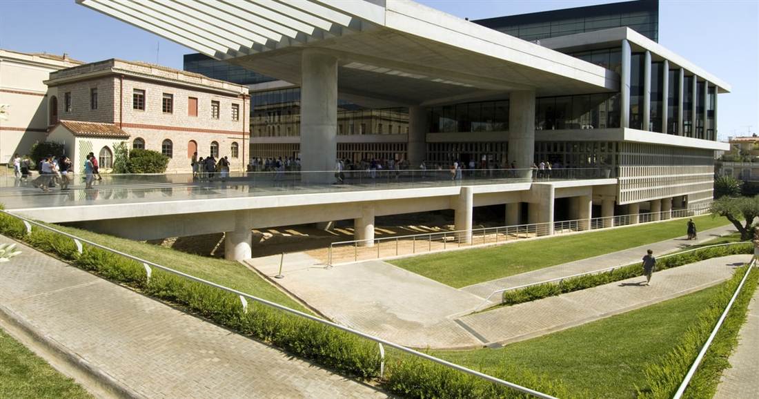 The modern glass and concrete Acropolis Museum with a wide, gently sloping walkway and lawns in front of the entrance, a stop on an Athens wheelchair accessible tour.