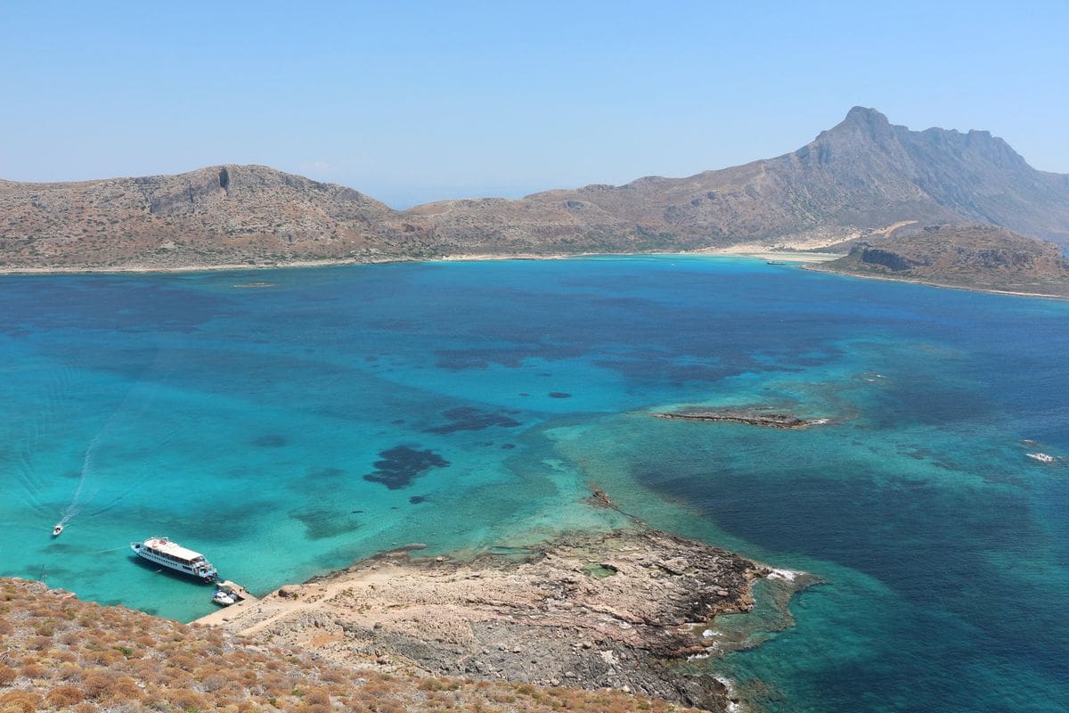 The Balos lagoon seen from Gramvousa with a cruise boat at anchor, on a Balos day trip from Heraklion