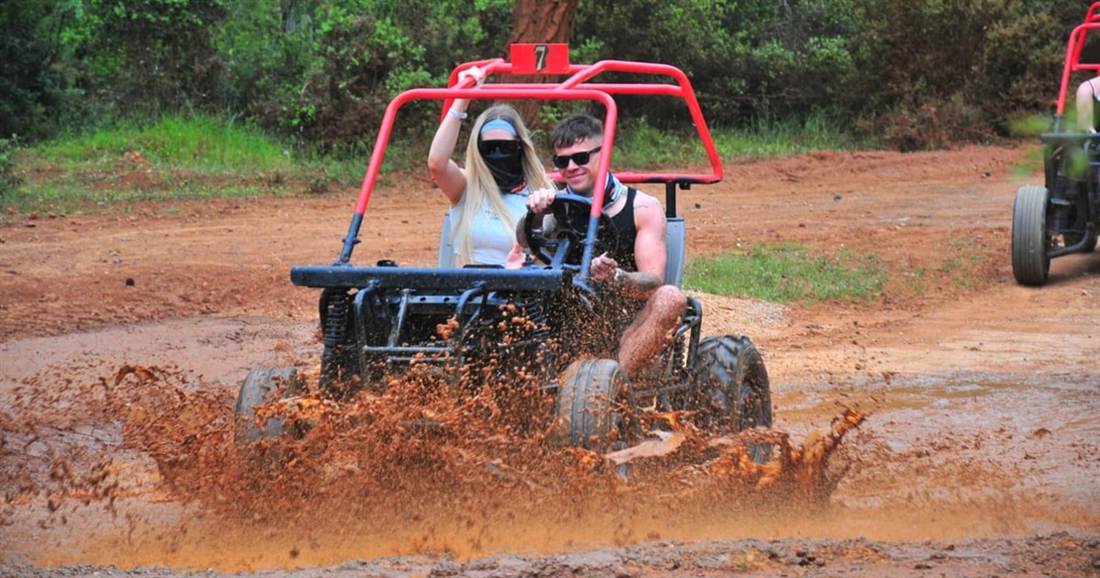 A buggy splashing through a red mud track in a pine forest near Bodrum.
