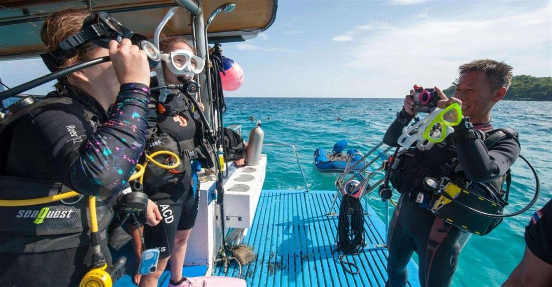 Divers in wetsuits and tanks getting ready on the deck of a dive boat off Bodrum.