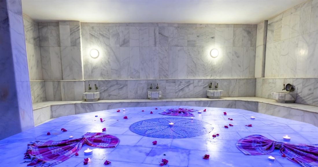 Marble hot room of a Bodrum hamam with the round heated stone in the centre and peştemal cloths laid out.