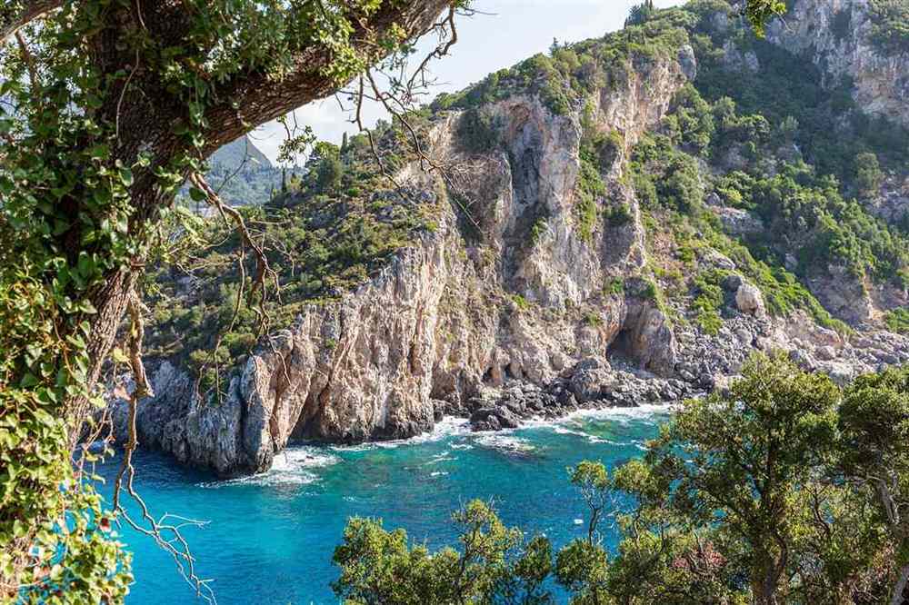Green cliffs and turquoise sea coves on the coast at Paleokastritsa, Corfu.