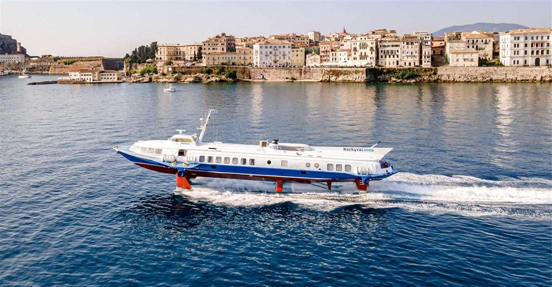 A hydrofoil ferry speeding past the waterfront of Corfu Old Town