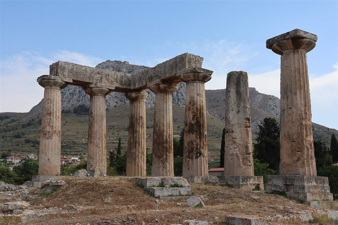The Doric columns of the Temple of Apollo at Ancient Corinth with the Acrocorinth rock behind