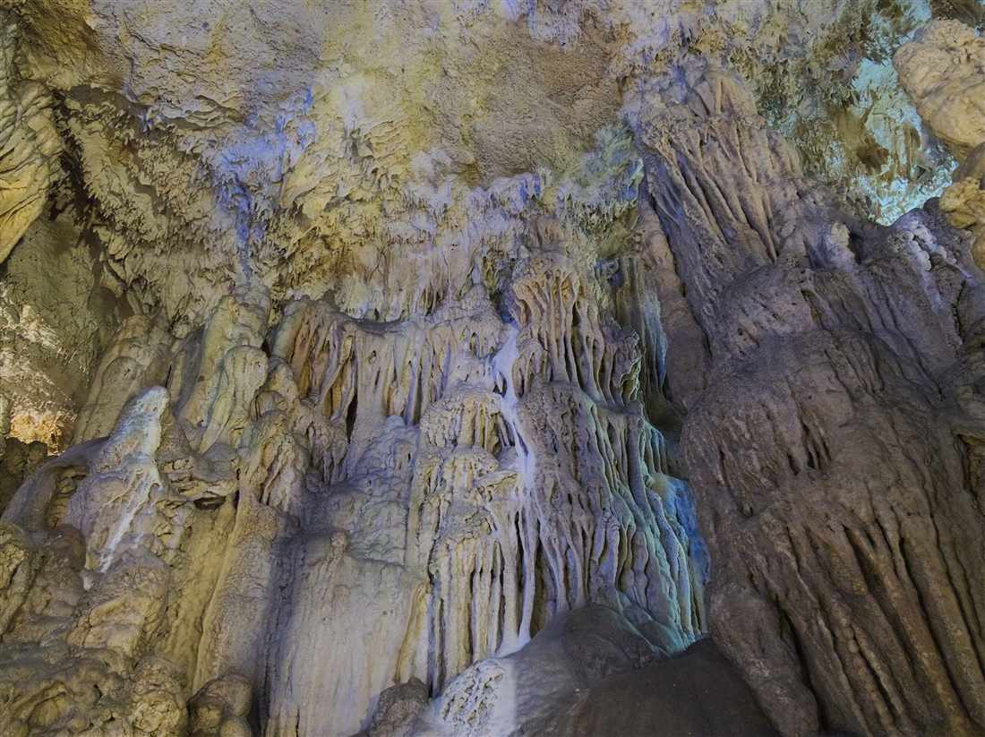 Stalactites and stalagmites lit along the walkway of the Sfendoni cave at Zoniana, a stop on a Crete cave tour.