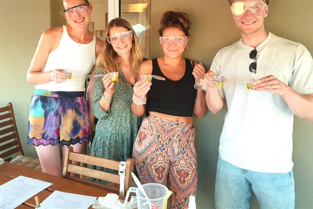 Guests in safety goggles holding their fresh bars of olive oil soap on a rooftop in Heraklion after Crete soap making.