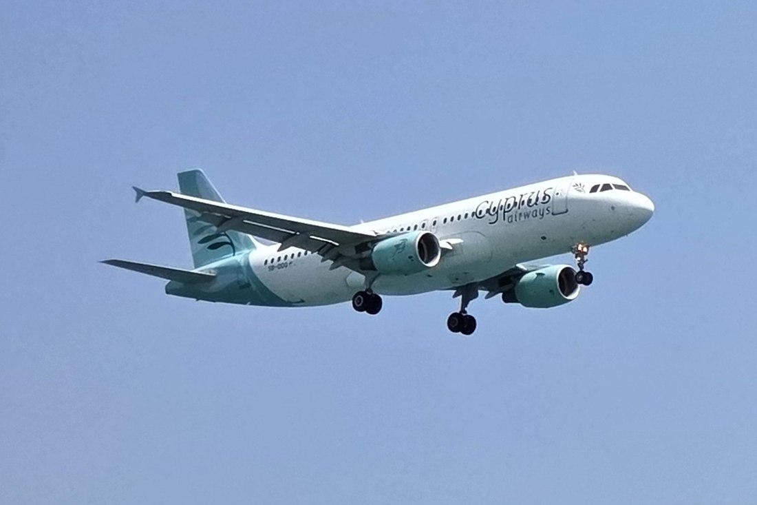 Cyprus Airways Airbus A320 with its landing gear down approaching to land under a clear blue sky