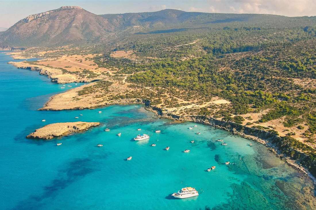Aerial view of the Blue Lagoon on the Akamas peninsula in Cyprus with boats anchored in turquoise water