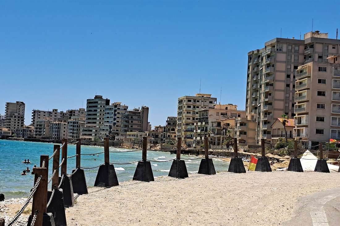 Beach in Varosha with chain barriers and abandoned high-rise hotels along the Famagusta shoreline