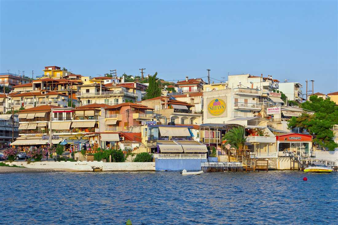 The colourful waterfront houses of Neos Marmaras on Sithonia above the sea, a resort reached by Halkidiki transfers from Thessaloniki airport.