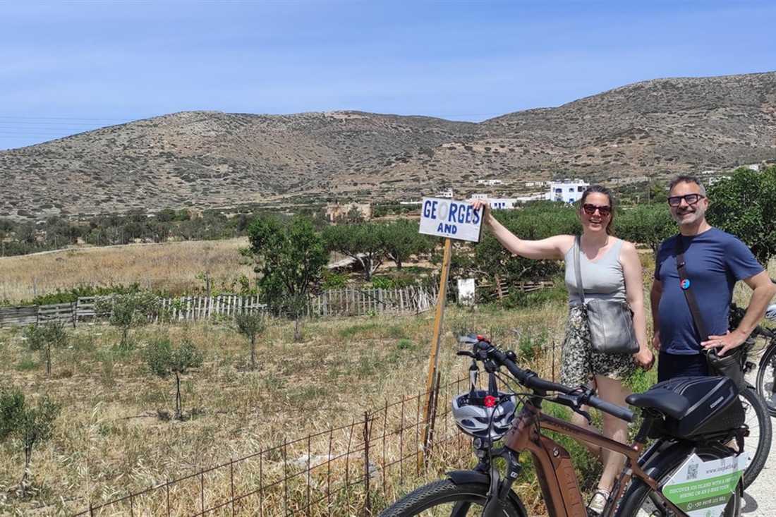 Two riders with electric bikes on a country road in the hills of Ios, on an Ios e-bike tour.