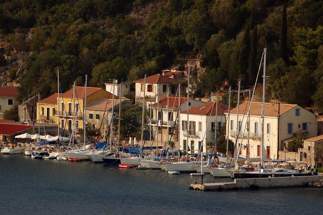 Sailing yachts moored along the waterfront of Kioni below green hills, the harbour an Ithaca boat trip reaches.