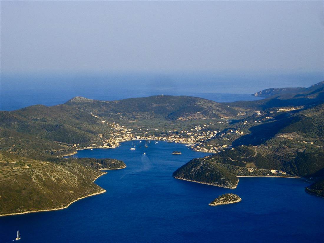 Vathy and its deep blue bay seen from the air between the green hills of Ithaca, the island visited on an Ithaca private tour.