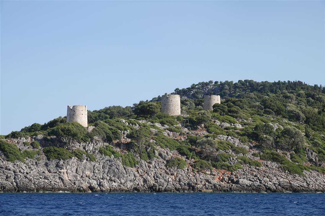 The ruined stone windmills on the headland above Kioni harbour, a stop in the north on an Ithaca private tour.