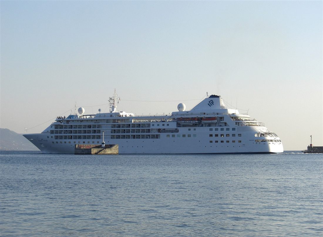 A white cruise ship arriving in the calm water of the Messenian Gulf at the port of Kalamata